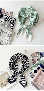 Silk satin square scarves with green stripes and floral prints on a textured glass plate