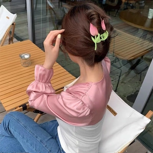 Close-up of pink tulip hair claw clip on model hair in an elegant outdoor setting