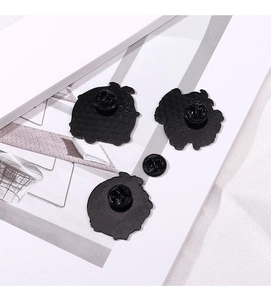 Detailed back view of black metal pins with butterfly clutches on a modern background