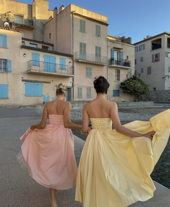 Detail of the elegant lace-up corset back on long strapless pink and yellow dresses