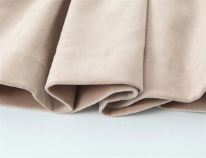 Vue macro détaillée de la texture du velours beige doux sur une robe plissée