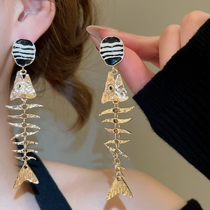 Macro detail of unique long fishbone drop earrings featuring black and white striped studs