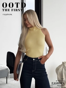 Detail of yellow ribbed knit vest with high neck and slim fit texture on model