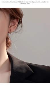 Close-up of minimalist S925 sterling silver hoop earring with twisted wave texture on model
