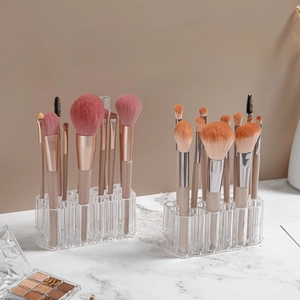 Clear acrylic 26-slot organizer for makeup brushes and pens on white marble surface