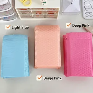 Thickened bubble mailers in light blue and pink tones on a clean white desk setup