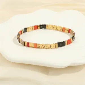 Detailed view of colorful Tila bead bracelet displayed on a white shell-shaped porcelain dish
