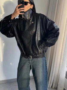 Détail d'une veste de moto noire avec col montant et ceinture réglable à la taille
