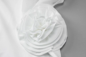 Gros plan sur la fleur en mesh blanc élégante de la robe midi sexy à épaules dénudées