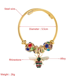 Detailed view of a gold braided wire bracelet featuring colorful rhinestone beads and a bee charm
