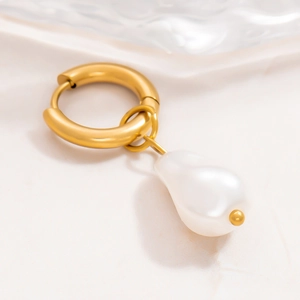 Macro shot of 18k gold stainless steel earring with a baroque freshwater pearl charm
