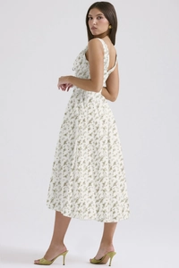 Detail view showing elegant floral print and side silhouette of white midi dress