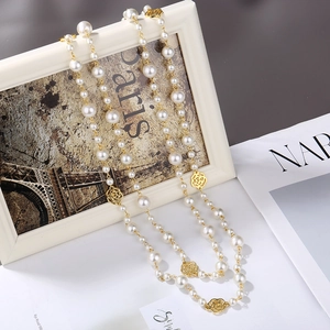 Elegant long pearl necklace with golden hollow camellia accents in a vintage French style