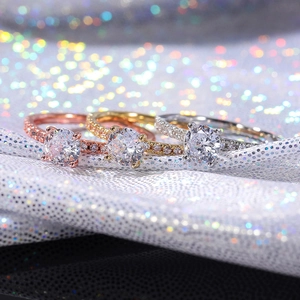 Three-piece ring set in rose gold, gold and silver featuring round cut central zircon stones