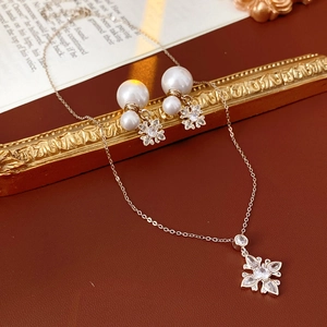 Elegant silver flower jewelry set with pearls and zircons shown on vintage background