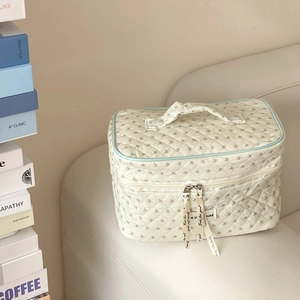 Detail der gesteppten Kosmetiktasche mit Blumenmuster und Just for you Schleife