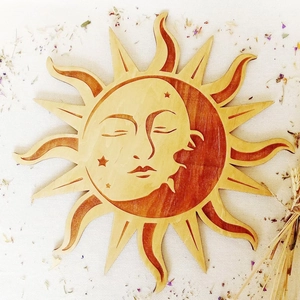 Detail of wooden sun and moon wall art with natural grain and bohemian celestial carvings