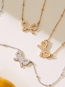 Detail of beaded chains with sparkling bow pendants in gold and silver finish