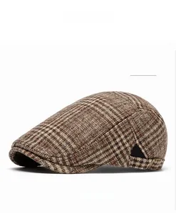 Close-up of khaki plaid newsboy hat featuring vintage texture and metal side buckle