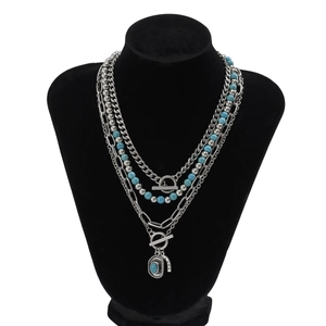 Detail of bohemian layered necklace with turquoise beads and OT buckle on display