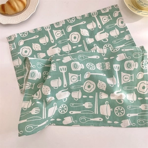 Gros plan du set de table en lin vert menthe avec motifs de cuisine blancs dessinés