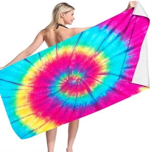 Detail of vibrant spiral tie-dye microfiber beach towel held by model showing back texture