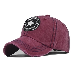 Detail of burgundy washed cotton baseball cap featuring star patch and distressed brim