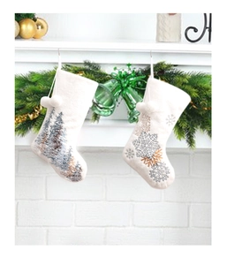 Detail of cream Christmas stockings with snowflake and pine tree patterns on a mantel