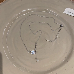 Dettaglio della collana Saturno argento con nucleo blu e piccoli ciondoli a stella