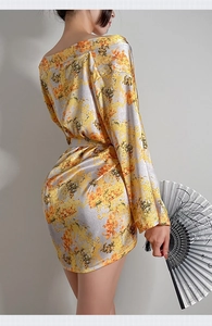 Detail eines gelben Satin-Kimonos mit Blumenmuster und weiten Ärmeln