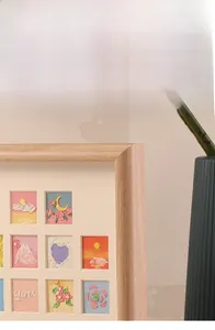 Detail of wooden shadow box frame featuring 3D oil pastel art with heart and floral motifs