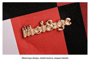 Gros plan du logo en métal doré sur le sac à main en cuir à carreaux rouge noir blanc
