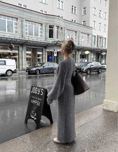 Détail d'une robe longue en maille côtelée grise avec grand sac cabas en ville
