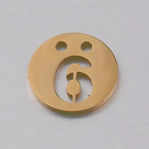 Vue macro du pendentif chiffre 6 en acier inoxydable doré avec double trou pour bijoux
