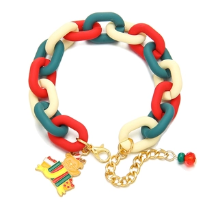 Détail du bracelet de Noël avec maillons rouge vert et breloques festives