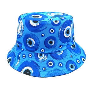 Detailed view of bucket hat featuring embroidered evil eye patterns on blue canvas fabric