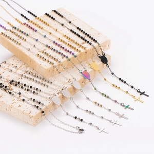 Stack of stainless steel geometric portrait pendant necklaces in multiple colors on stone