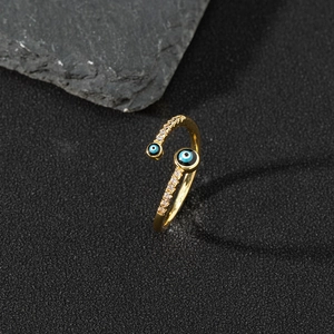 Macro detail of golden evil eye open ring featuring blue enamel and sparkling cubic zirconia