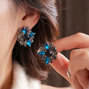 Vintage flower earrings with blue rhinestones and black crystals for a retro luxury look