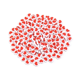 Macro shot of 8mm white acrylic heart beads with red patterns for DIY jewelry making