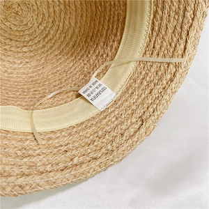 Detail view of the 100% Raffia bucket hat inner lining with sweatband and fabric care label