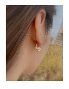 Detailed close-up of a S925 silver pearl earring with zircon accents on a person ear