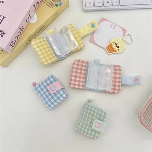 Detailed view of mini plaid card albums in pastel colors with heart button closure