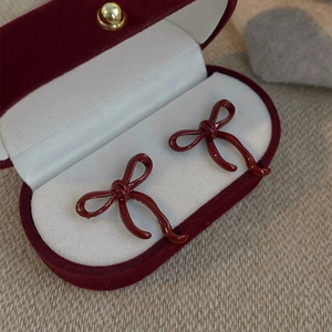 Classic wine red bow earrings in a premium velvet gift box on a soft beige background