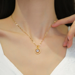 Elegante collana in titanio dorato con pendente tondo in zircone su una modella