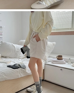 Detailansicht beige Freizeithose und klassisch schwarz-weiß gestreifte Baumwollsocken