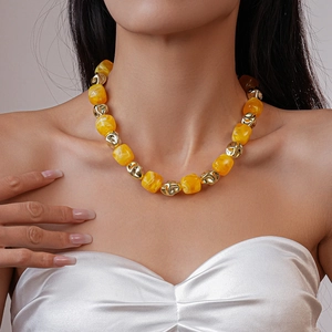 Detail of yellow acrylic beads and gold irregular metal beads on a statement necklace