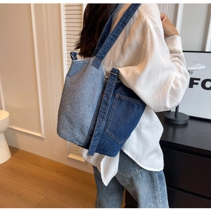 Detail of vintage denim patchwork tote bag with external pockets shown on model