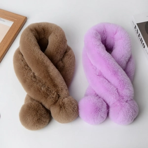 Detailed view of plush faux rabbit fur scarves with pom-pom ends in light brown and lavender