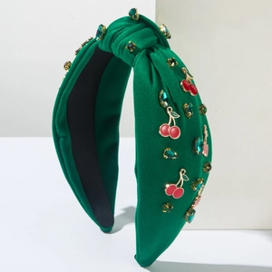 Détail du serre-tête noué vert avec breloques cerises rouges et pierres vertes